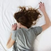 A woman sleeping on a bed after she found the right mattress firmness for her