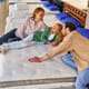 A young family with their lovely daughter lay down on the bed, trying the mattress for softness in the store. Buying a mattress